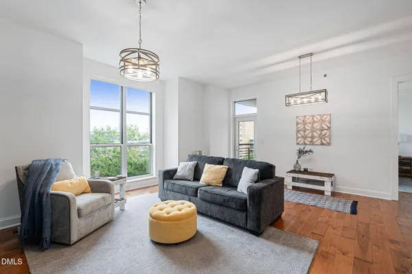 a living room with furniture chandelier and a window