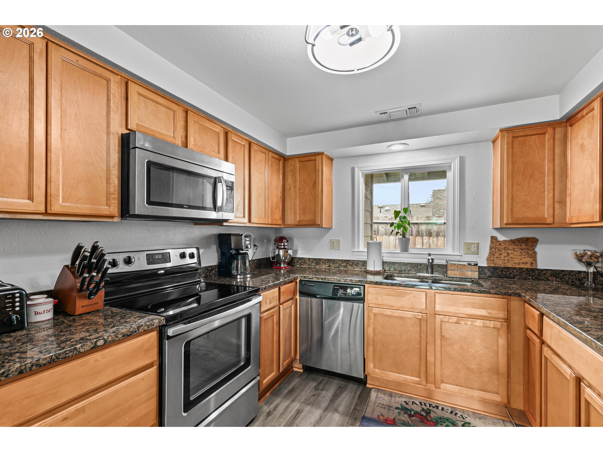3712 Colver Road Phoenix, OR 97535 - Photo 9 of 38 a kitchen with stainless steel appliances granite countertop a sink a stove a microwave cabinets and a counter top space