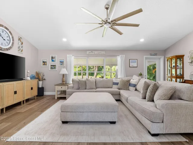 a living room with furniture a flat screen tv and a large window