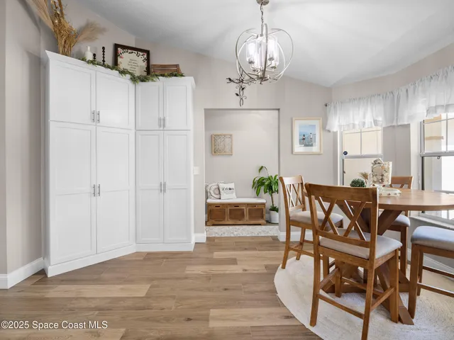 a view of a dining room with furniture and chandelier