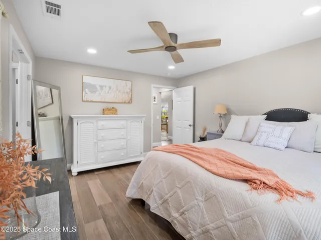 a spacious bedroom with a bed and a dresser