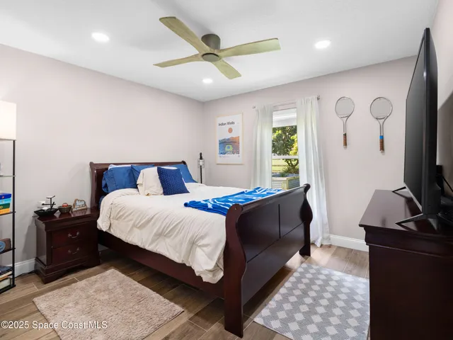 a bedroom with a bed and a flat tv screen on the dresser