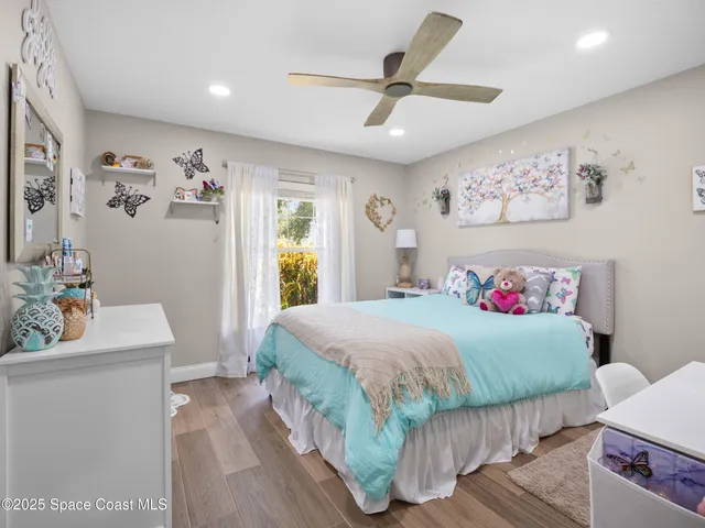 a bedroom with a bed and a wooden floor