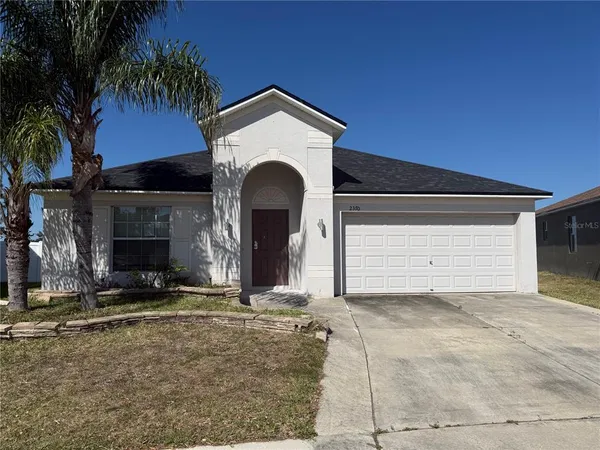 a view of house with yard and garage