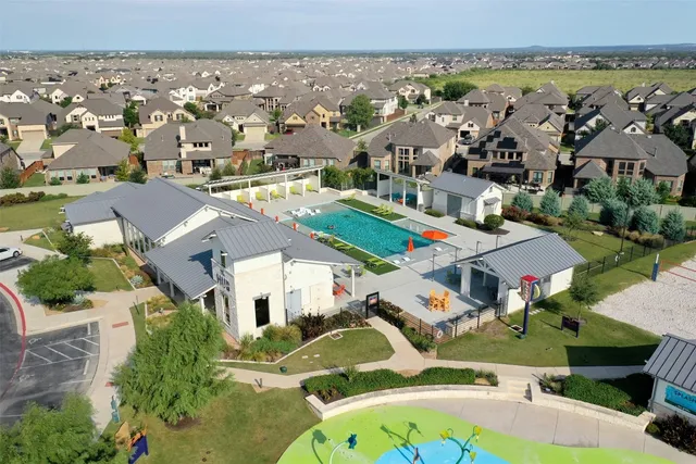 an aerial view of residential houses with outdoor space and parking