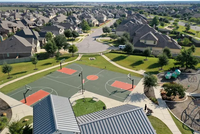 an aerial view of residential houses with outdoor space and swimming pool