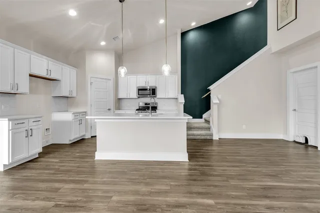 a kitchen with stainless steel appliances a sink dishwasher stove refrigerator and microwave