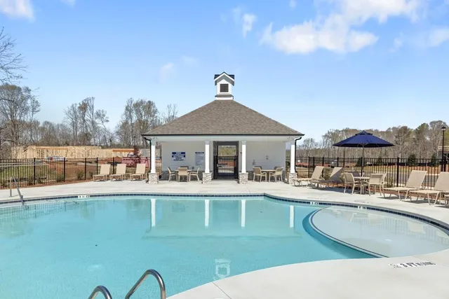 a view of a house with a bath tub and couches next to red umbrella