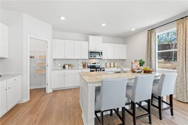 a living room with furniture and view of kitchen