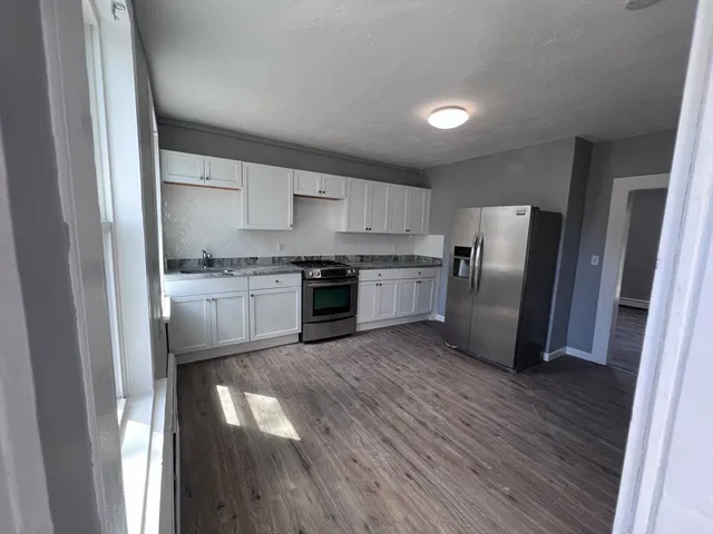 a kitchen with wooden floors and stainless steel appliances