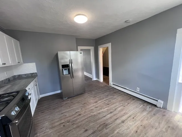 a view of a kitchen with refrigerator stove and wooden floor