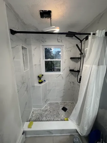a bathroom with a shower and a window