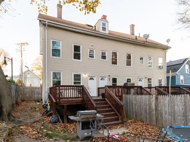 a view of a house with wooden deck front of house