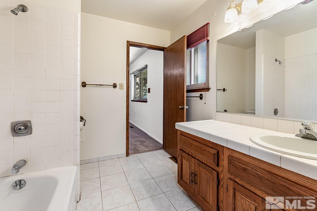 11040 Broken Hill Road Reno, NV 89511 - Photo 17 of 24 a bathroom with a sink a mirror and a bathtub