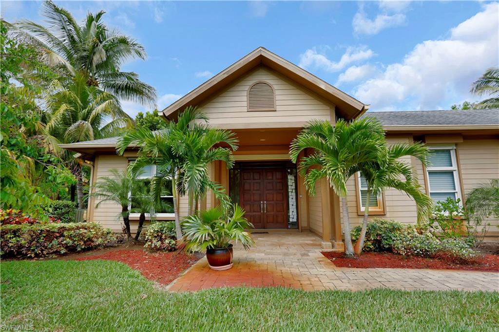 215 Auto Ranch Road Naples, FL 34114 - Photo 2 of 21 a front view of a house with a yard and potted plants