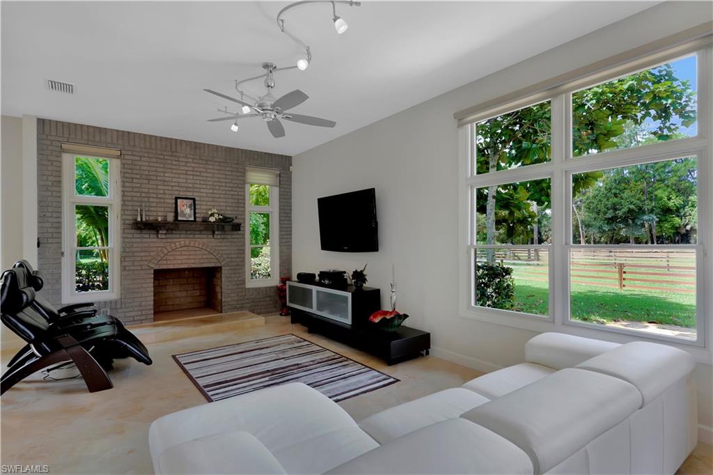 215 Auto Ranch Road Naples, FL 34114 - Photo 5 of 21 a living room with furniture a fireplace and a flat screen tv
