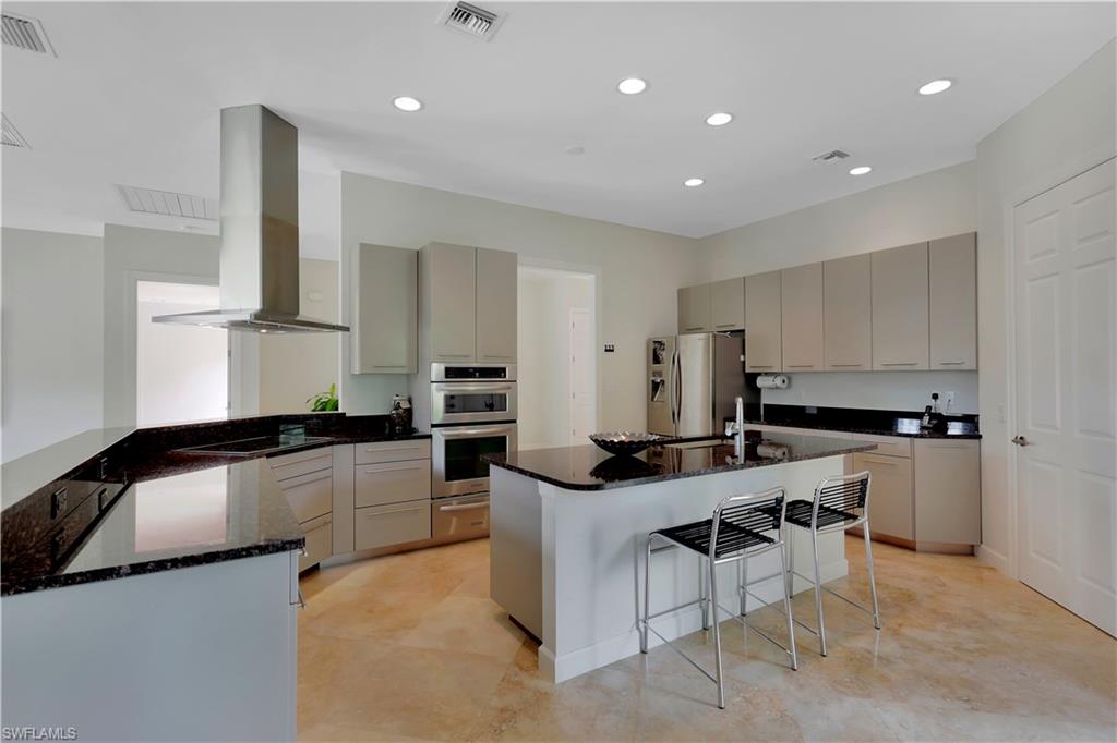 215 Auto Ranch Road Naples, FL 34114 - Photo 6 of 21 a kitchen with stainless steel appliances kitchen island granite countertop a sink and cabinets