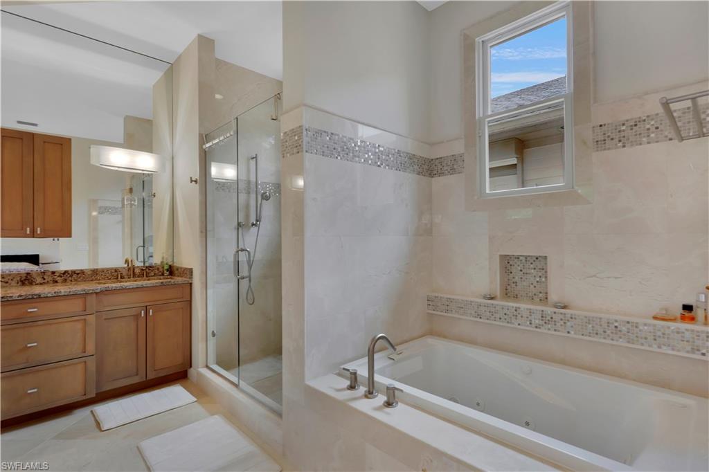 215 Auto Ranch Road Naples, FL 34114 - Photo 10 of 21 a bathroom with a tub a sink and mirror