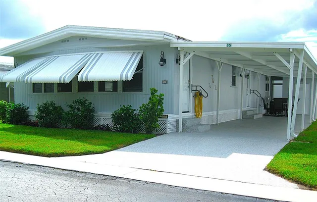a view of a house with potted plants and a yard