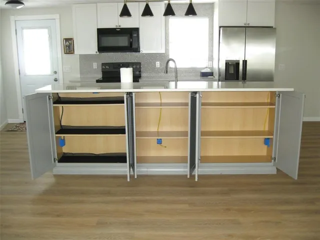 a kitchen with a sink and a wooden floor