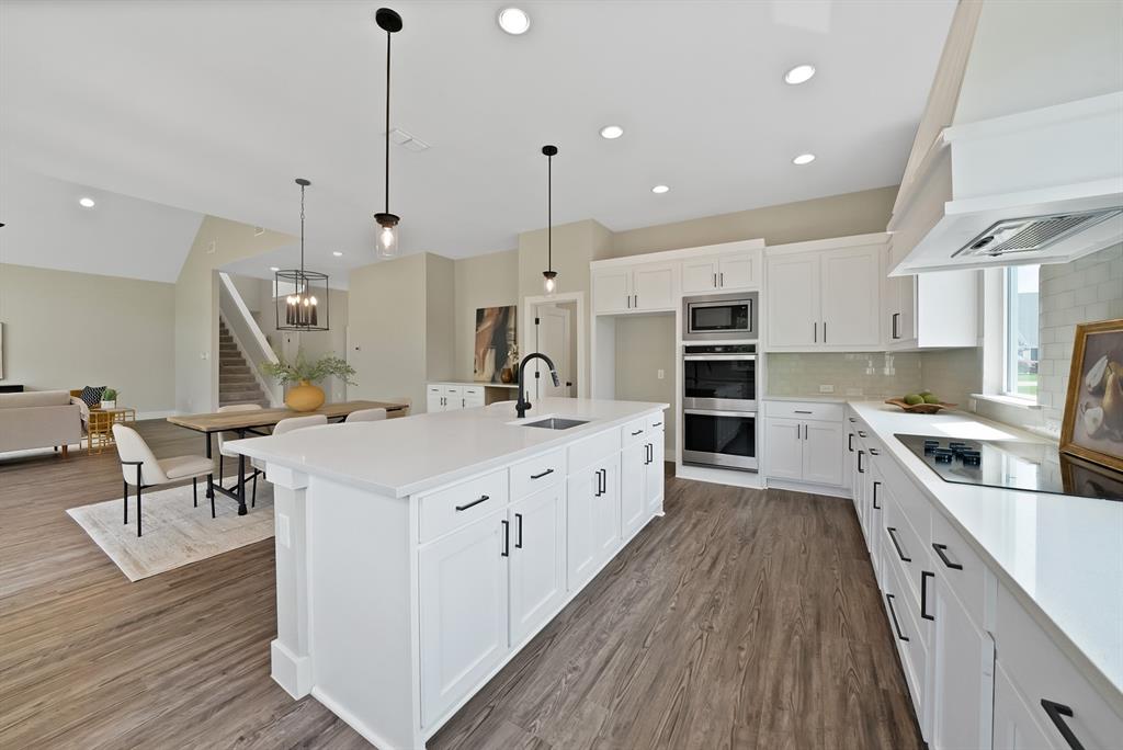 2223 Providence Way Nevada, TX 75173 - Photo 21 of 40 a large kitchen with kitchen island granite countertop lots of counter space a sink appliances and cabinets