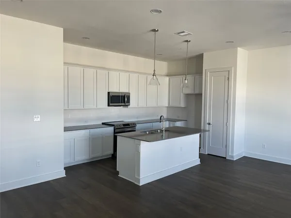 a kitchen with stainless steel appliances a white stove top oven sink and cabinets