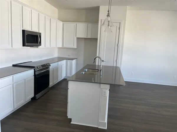 a kitchen with stainless steel appliances granite countertop a sink stove and microwave