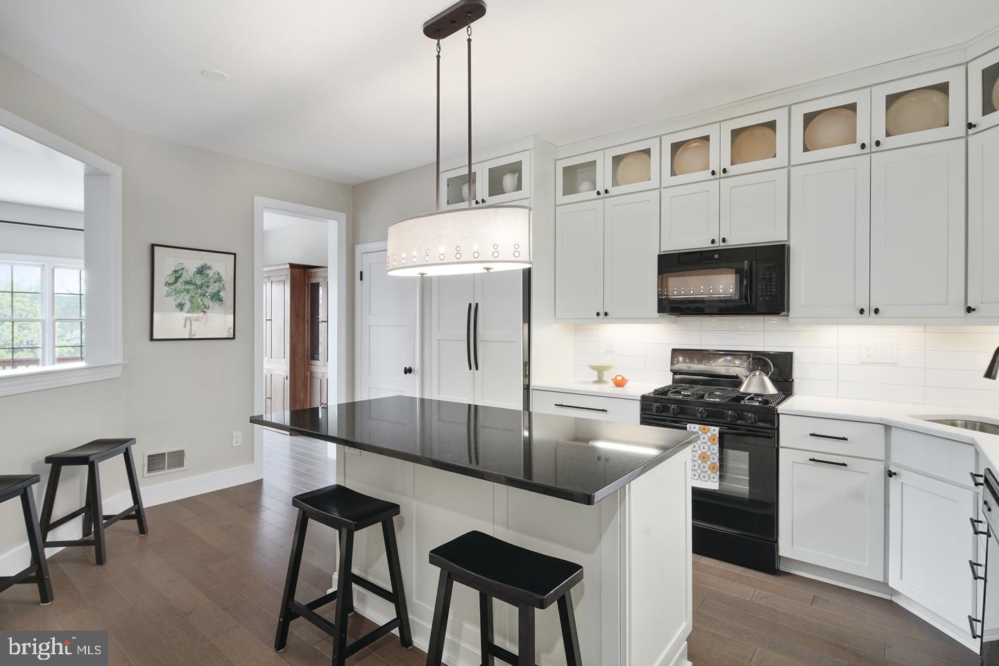 a kitchen with granite countertop a table chairs stove and cabinets