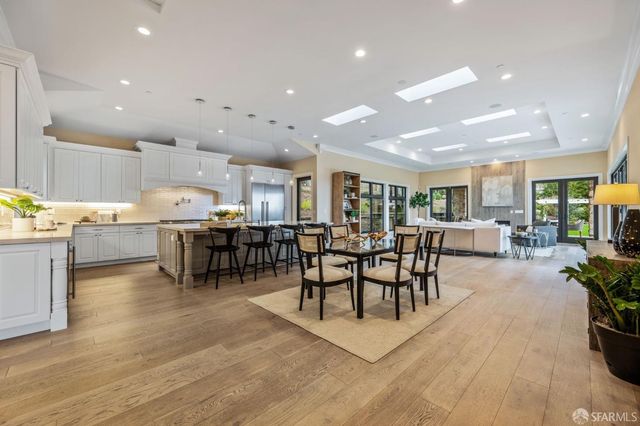 a living room with stainless steel appliances furniture and a wooden floor