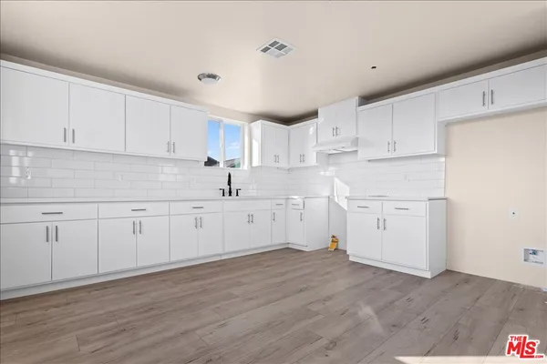 a kitchen with white cabinets and white appliances