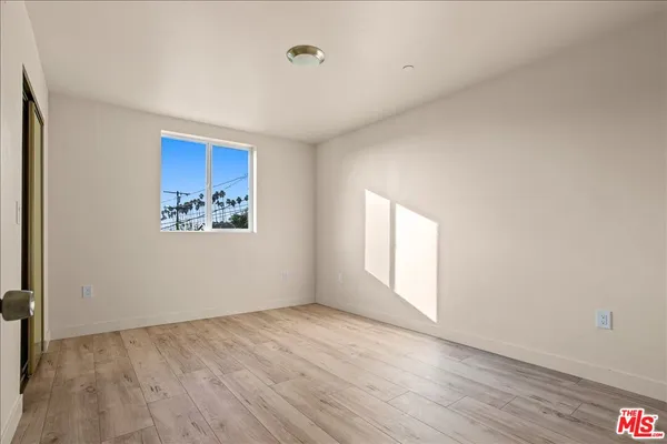 an empty room with wooden floor and a window