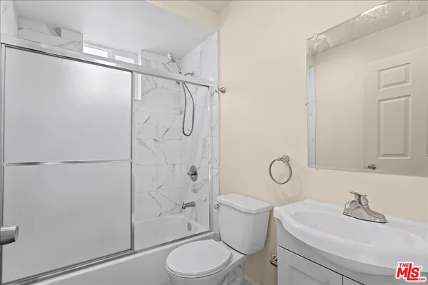 a bathroom with a granite countertop sink toilet and shower