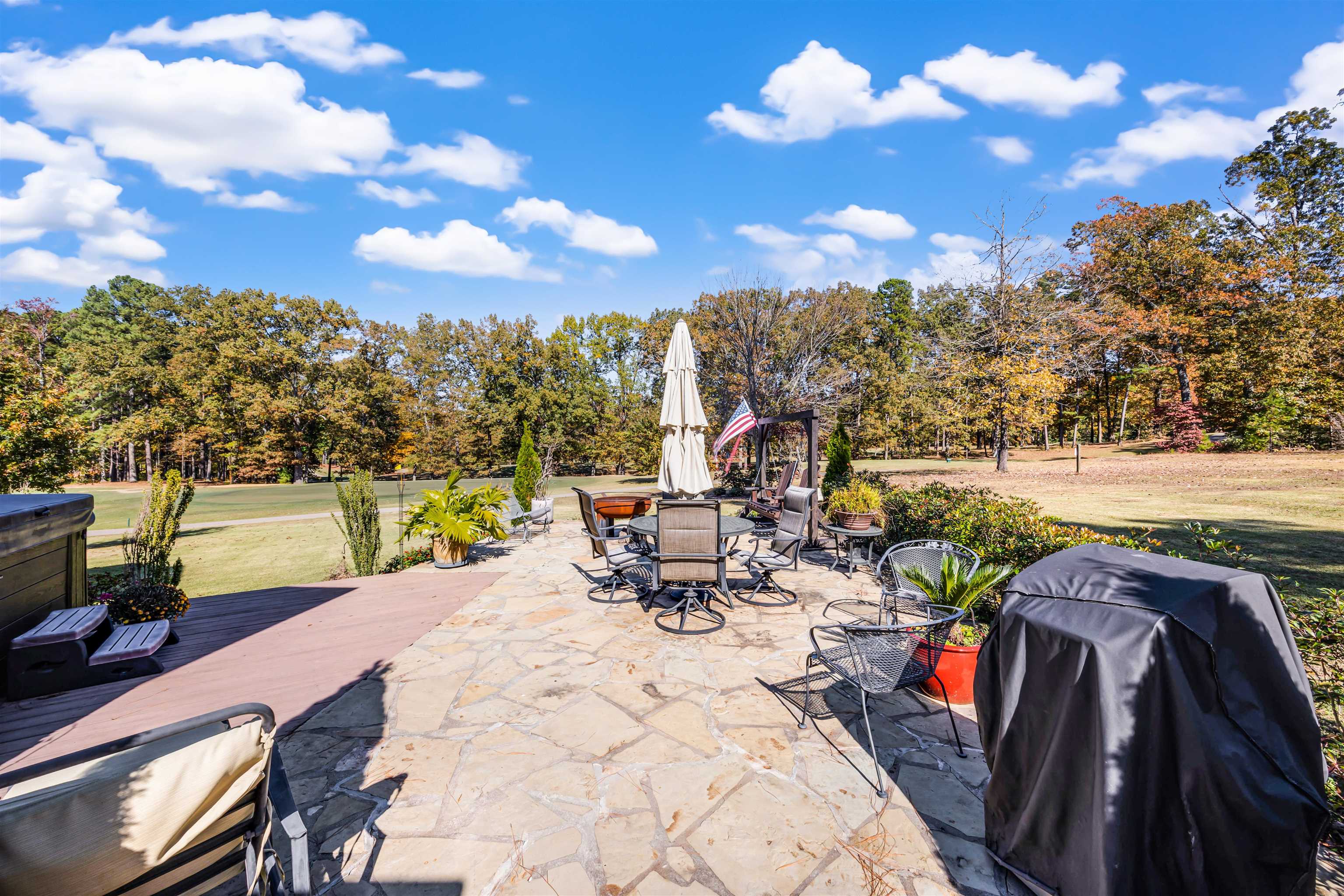 140 Legends Drive Counce, TN 38326 - Photo 24 of 30 View of patio with view of wooded area, grilling area, outdoor dining space, and a hot tub