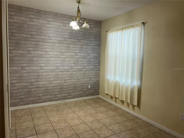 a view of a livingroom with an empty space and a window