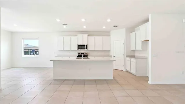 a view of kitchen with white cabinets stainless steel appliances and window