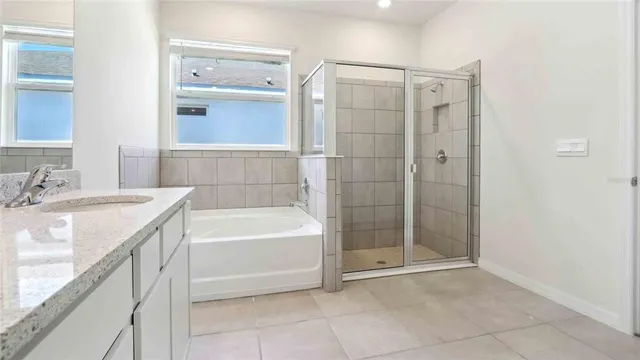 a bathroom with a granite countertop sink a mirror and a bathtub