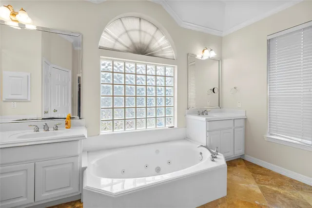 a bathroom with a bathtub a sink a window and a mirror