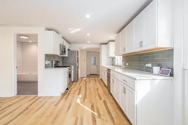 a kitchen with kitchen island granite countertop lots of counter top space and refrigerator