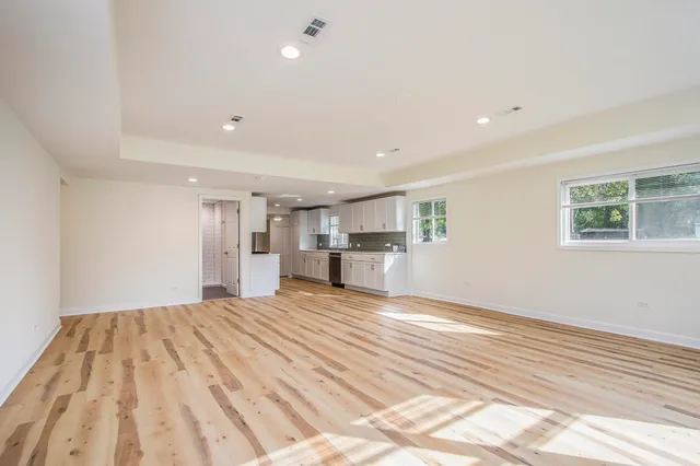 a view of empty room with wooden floor and window