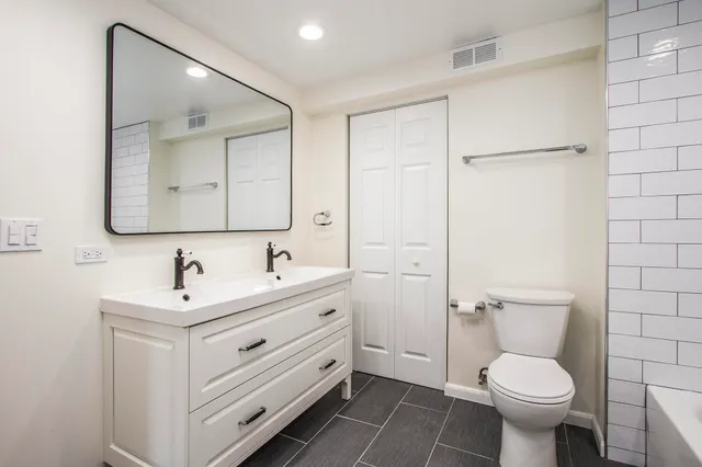 a bathroom with a toilet sink and mirror