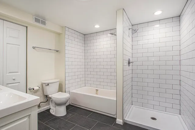 a bathroom with a shower a bathtub and a toilet