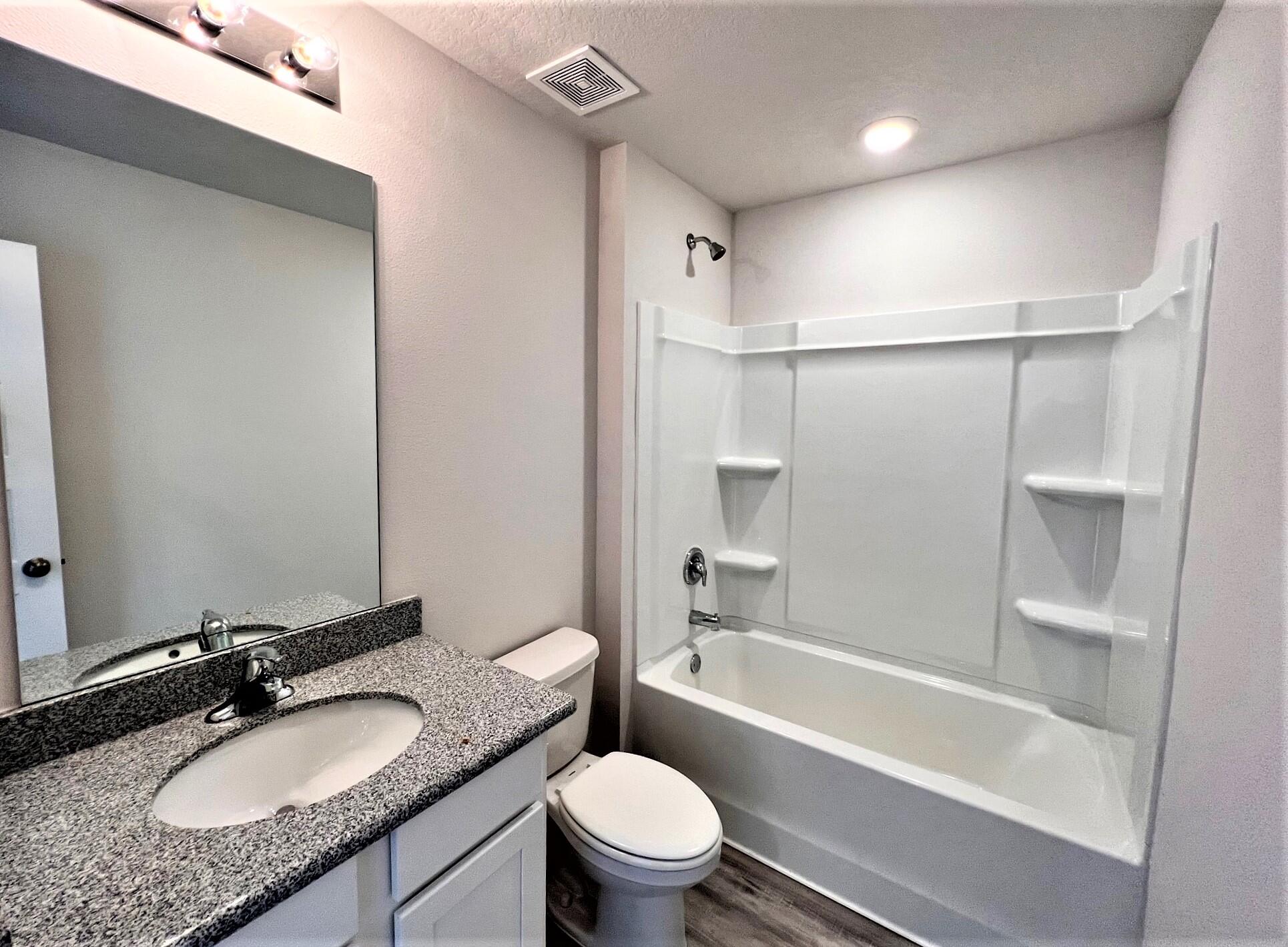 3017 Jane Lane Crestview, FL 32539 - Photo 14 of 17 a bathroom with a granite countertop sink toilet mirror and shower