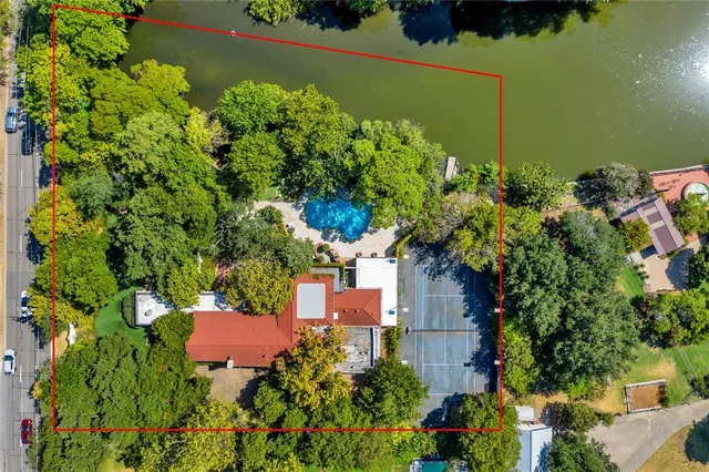 an aerial view of a house with a yard and lake view