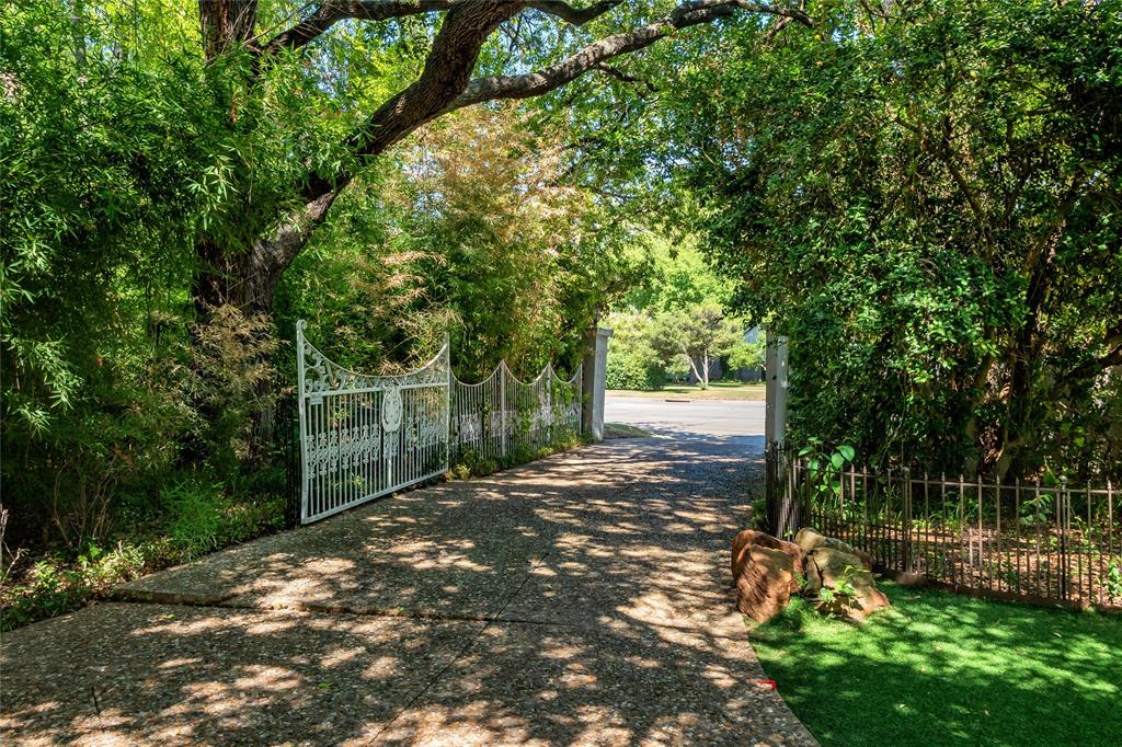 9909 Preston Road Dallas, TX 75230 - Photo 2 of 22 a view of a yard with plants and large trees
