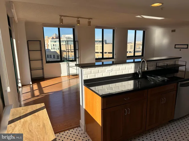a kitchen with granite countertop a stove a sink and a refrigerator