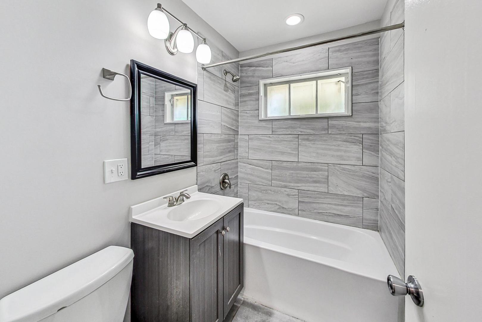 1205 183rd Street Homewood, IL 60430 - Photo 12 of 20 a bathroom with a toilet sink and mirror