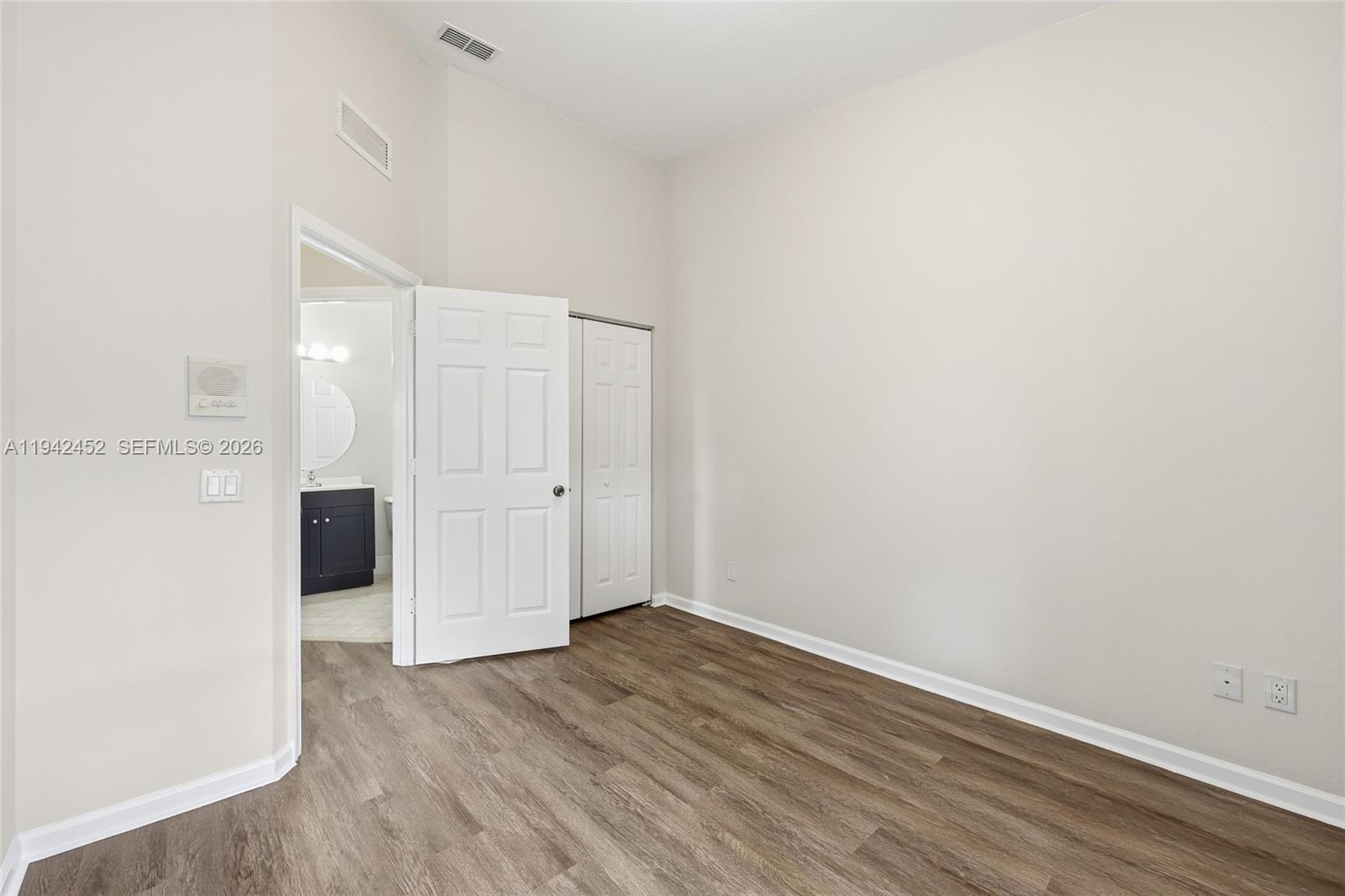 3059 Laurel Ridge Circle Riviera Beach, FL 33404 - Photo 24 of 25 an empty room with wooden floor and white walls
