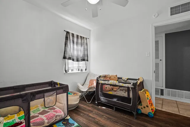 a living room with furniture and a baby crib