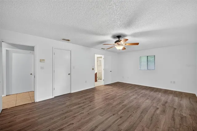 a view of empty room with wooden floor