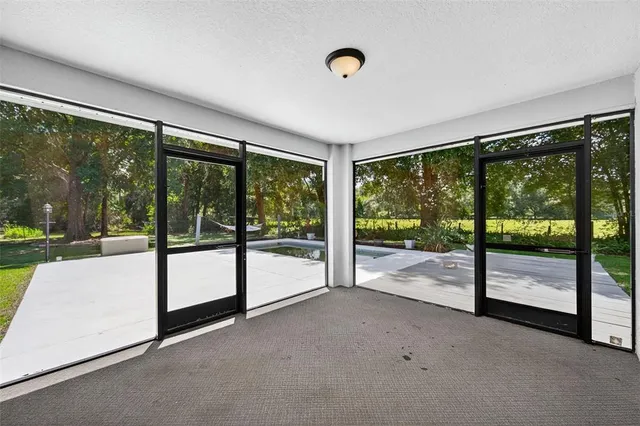 a view of an empty room with wooden floor and a floor to ceiling window